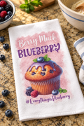 Blueberry muffin towel lying on the counter with Berry Much wording
