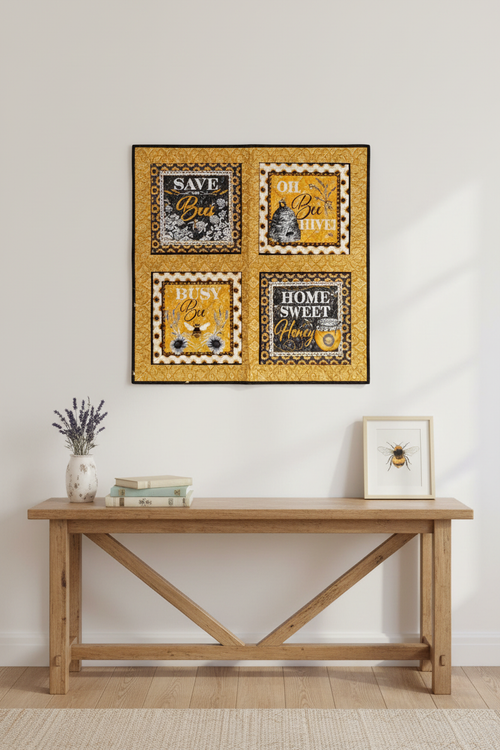 Bee-themed quilted wall hanging displayed on a white wall in a cozy cottage interior