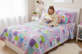Pastel patchwork quilt spread across a girl's bed in a bright cheerful bedroom